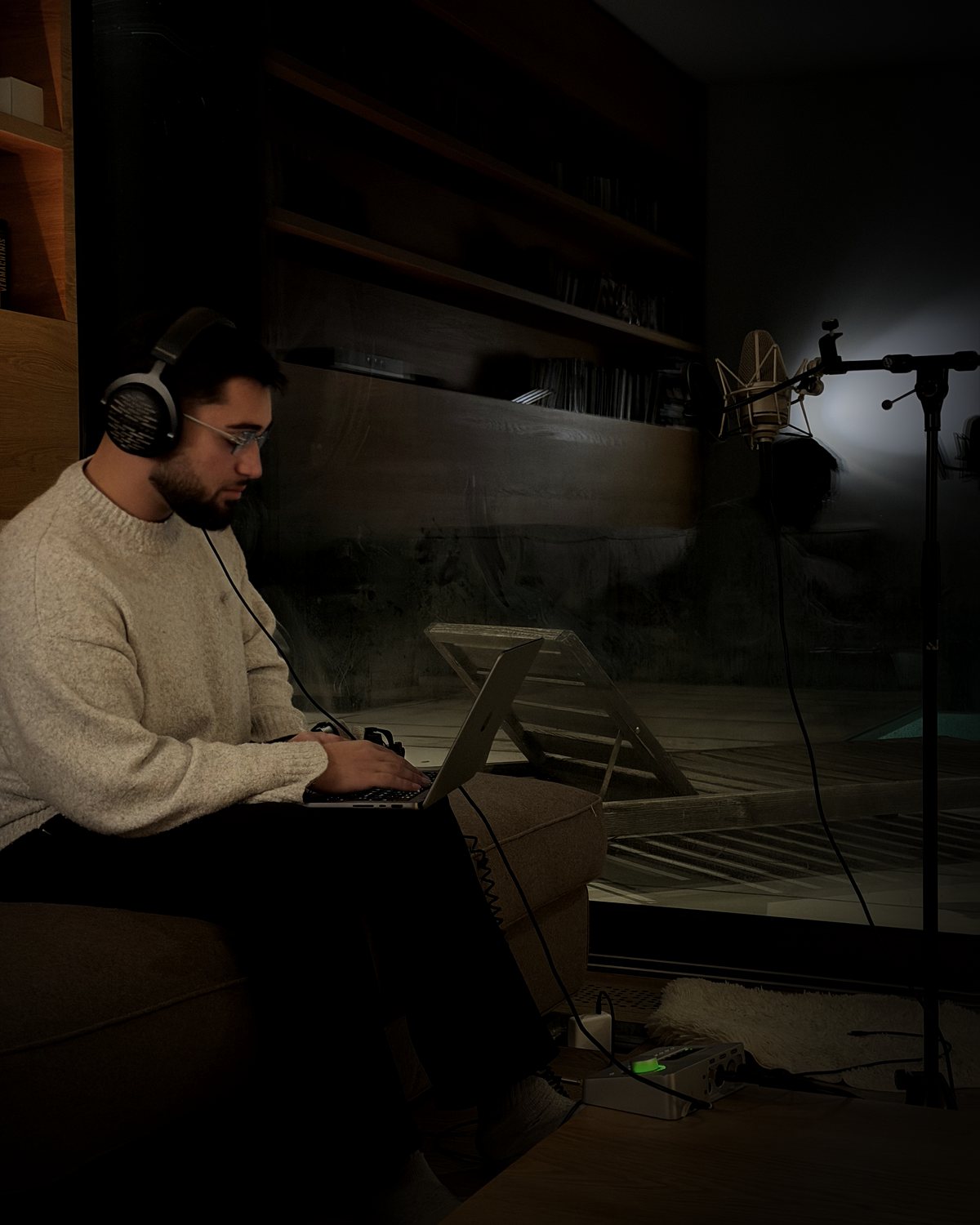 The founder of FORM DSP with headphones at a laptop next to a microphone